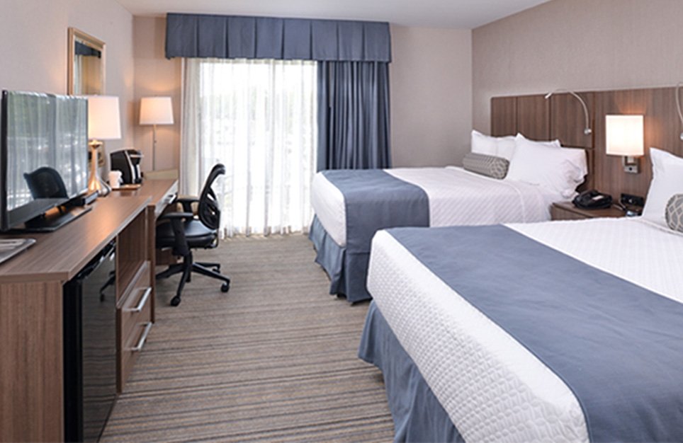 Deluxe Double Room with Balcony Room with two queen beds, tv, desk and a balcony